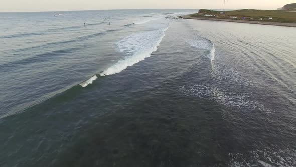Drone View of Surfers Waiting for a Wave in the Sea at Sunset