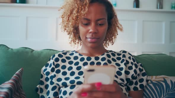 Concentrated African American Woman Sends Text Message From Mobile Phone