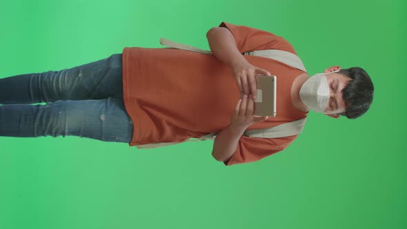 Asian Boy Student Wearing A Mask, Using Tablet While Walking To School On Green Screen