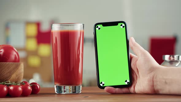 Woman Pouring Tomato Juice and Holding Smartphone with Chroma Key Fresh Red Vegetable Juice on