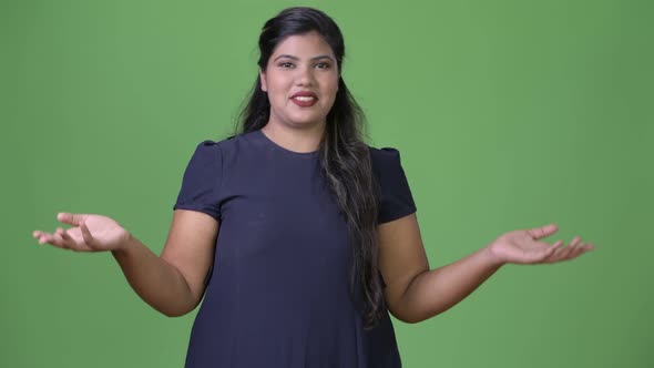 Young Overweight Beautiful Indian Businesswoman Against Green Background