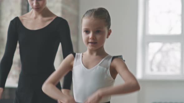 Adult And Small Ballerinas Dancing Synchronically