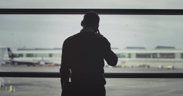 Man Speaking on His Phone in the Airport at