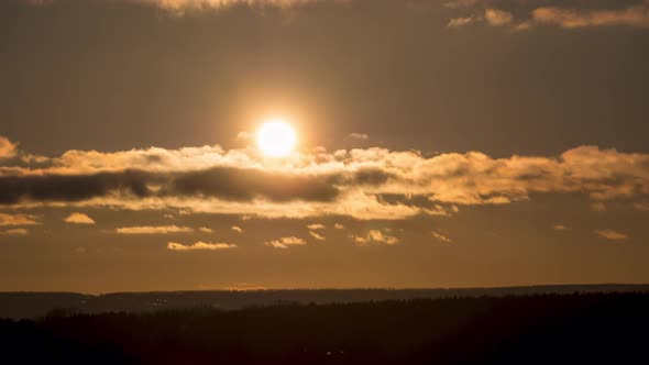 Dramatic Sunset Over the Clouds. Timelapse. Big Yellow Sun Moves Over the Horizon