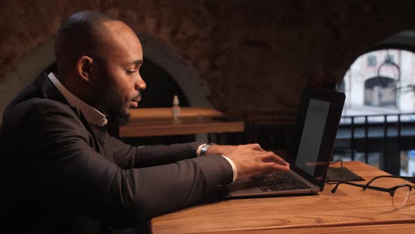 a Young Aspiring AfricanAmerican Investor Works at a Computer Analyzes the Securities Market