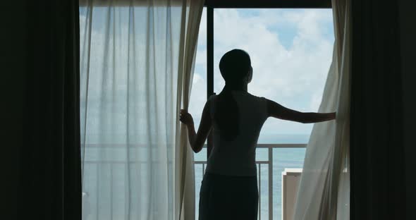 Woman open curtain at the morning