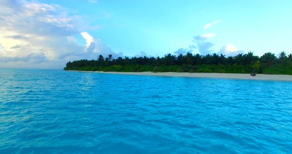 Wide fly over travel shot of a sunshine white sandy paradise beach and turquoise sea background in c