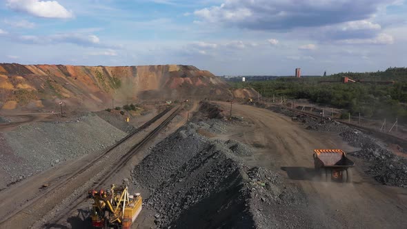 Large Mining Dump Truck Driving on a Dusty Road in the Quarry