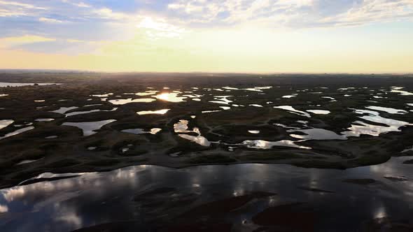 Aerial panorama of scattered lakes reflecting a golden sunrise, Potholes, Washington