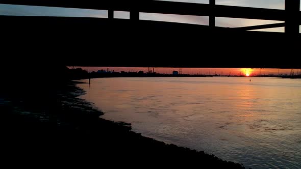 The Antwerp International Port. Sunset. Titlt up drone shot. Bridge Silhouette.