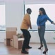 Young multi ethnic couple doing happy dance in new home - VideoHive Item for Sale