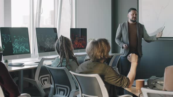 Businessman Delivering Financial Presentation to Colleagues