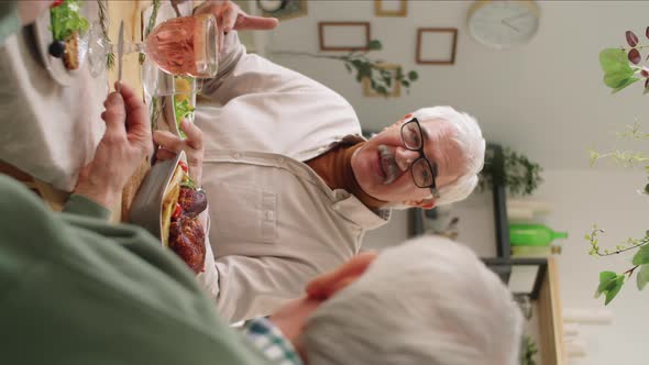 Cheerful Senior Man Chatting with Friend at Holiday Dinner