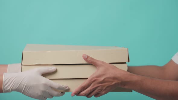 Isolate background, Asian delivery man holding pizza box delivery in hands and giving to customer.