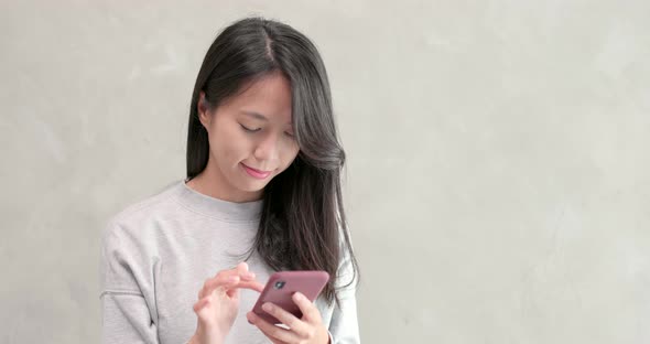 Woman use of mobile phone over grey background