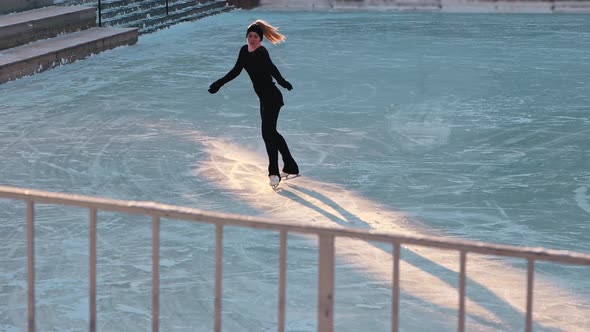 Young Woman Training Her Figure Skating on a Frozen Lake