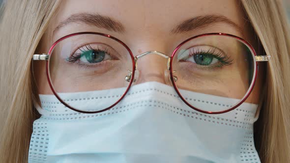 Extreme Close Up Female Face Caucasian Girl Woman with Blue Eyes Wear Glasses and Medical Mask