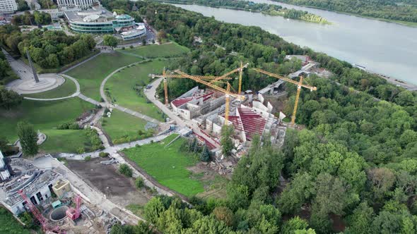 Aerial View Construction of a New Building with High Tower Cranes in Green Area