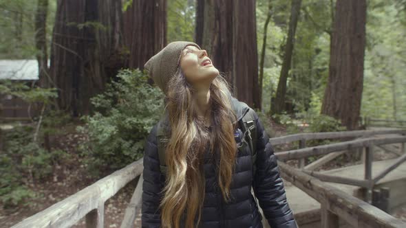 Young Woman Walking Around Redwood Forest Looking at Trees in Awe
