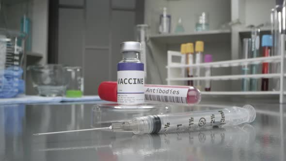 Vaccine and antibodies vial in medical lab with syringe