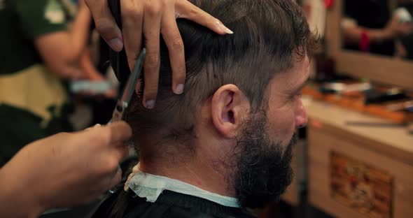 Professional Barber Shaves Customer Beard with Straight Razor