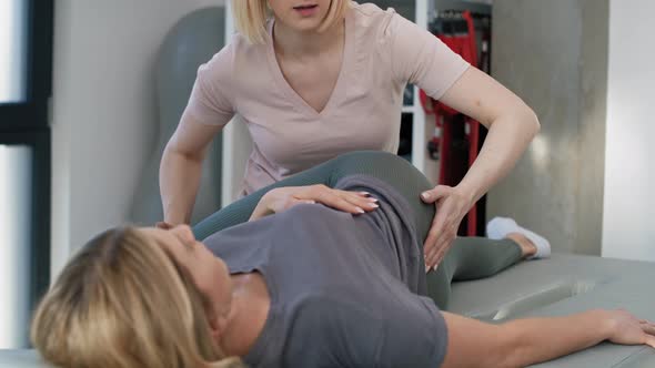 Female physical therapist helping her patient with back problems. Shot with RED helium camera in 8K.