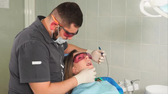 Professional Dentist Making Dental Treatment to Female Patient