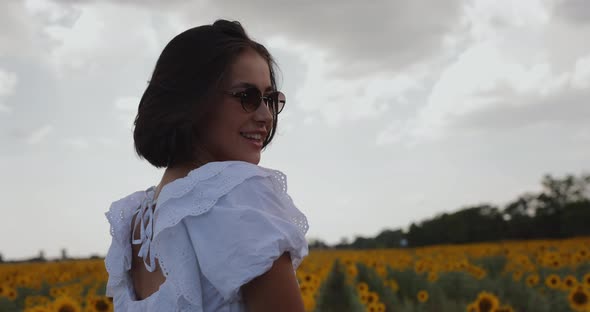 Beautiful Woman Walking in Sunflower Field