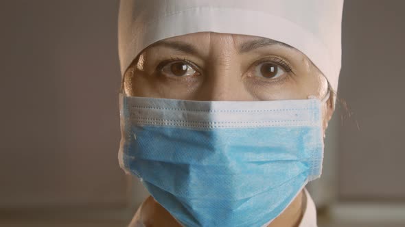 Closeup portrait of an experienced Caucasian female surgeon, doctor with mask ready for work in a ho