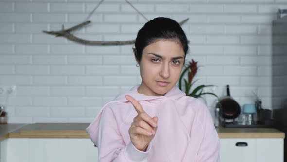 A Young Indian Woman Stands In A Bright Room Kitchen And Points Her Finger No No No