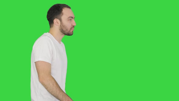 Sleepy Male in White Tshirt Yawning and Rubbing Eyes While Walking on a Green Screen Chroma Key