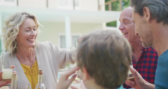 Happy caucasian family having dinner and talking in garden