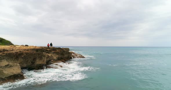 Couple walking on the rocky sea coast 4k