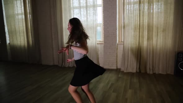 Teenage girl spinning and dancing in the studio slow motion