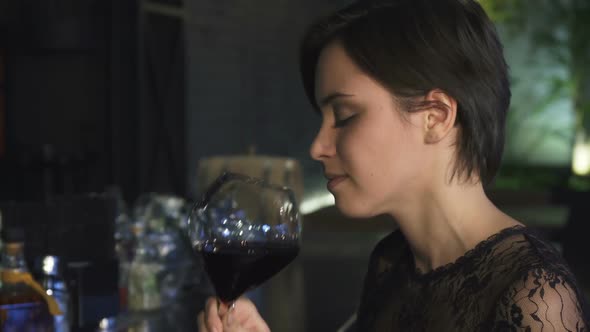 Cropped Shot of a Gorgeous Brunette Enjoying Drinking Wine at the Bar Smiling To the Camera