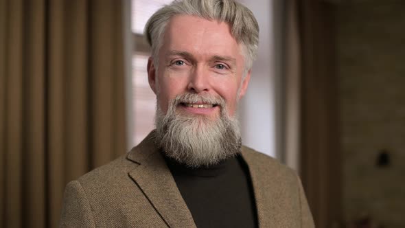 Portrait of a respectable man with a gray beard in a jacket
