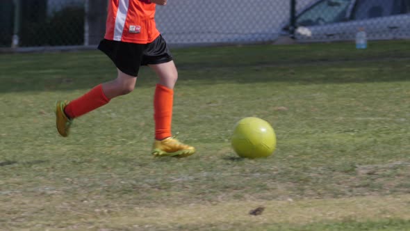 Young boy playing goalie in a youth soccer league game.