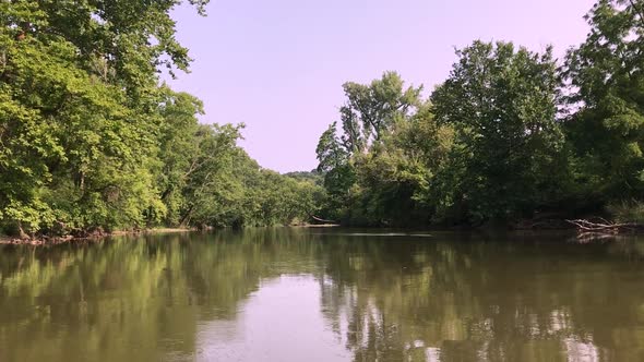 Kayaking and walking through a river and lake with stones and greenery all over. Serene nature shots