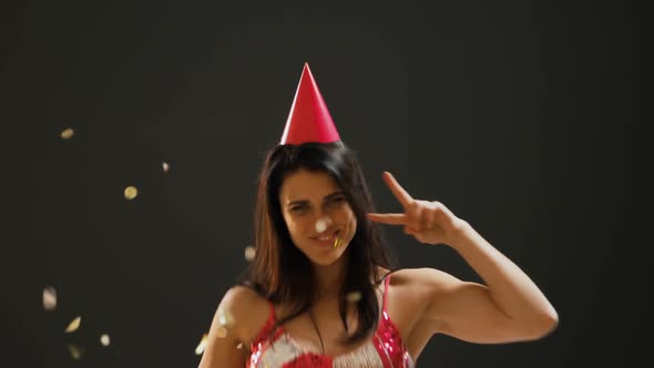 Young woman dancing in party hat