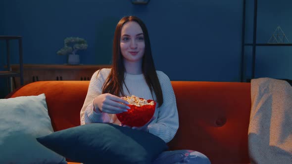 Woman Sitting on Sofa Alone Eating Popcorn and Watching Interesting Tv Serial Horror Film at Home