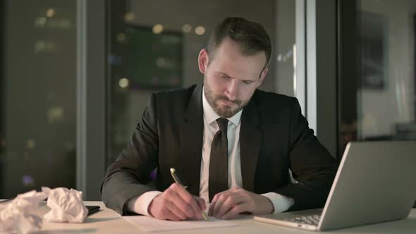 Ambitious Businessman Trying to Write Document at Night