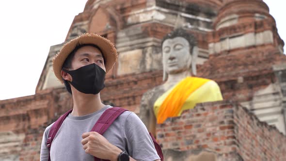 Asian Man Smiling in Face Mask Traveling to Ayutthaya Thailand to Prevent From Coronavirus Covid19