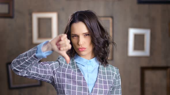 Medium Closeup Upset Casual Businesswoman Showing Gesture Dislike Thumbs Down Looking at Camera