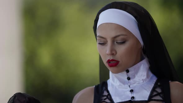 Voluptuous Sinful Nun is Walking in Garden Closeup Portrait