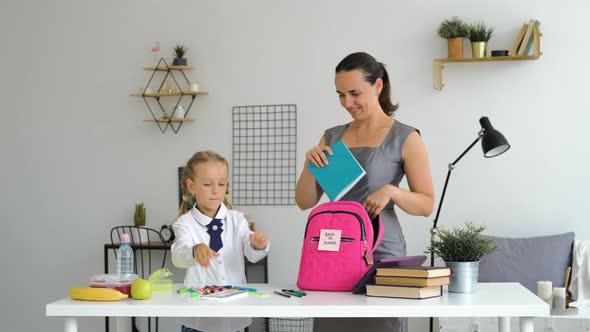 Little Girl with Mom Preparing School Backpack