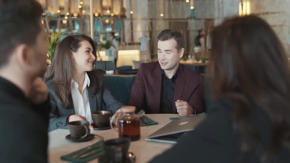 Diverse Group of Business Coworkers Sitting at a Table in Restaurant