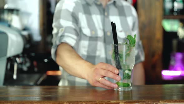 Barman is preparing a fresh, cold cocktail on the bar counter. Incredible Mix