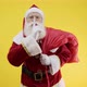 Santa Claus with red sack keeping forefinger by his mouth and looking at camera. Shh! Confidential. - VideoHive Item for Sale