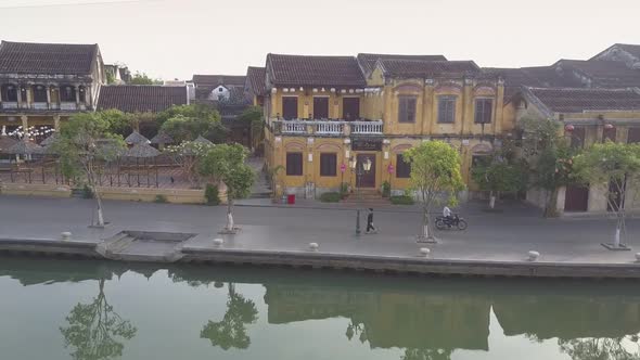 Upper Motion Past Yellow Buildings on Embankment with Trees