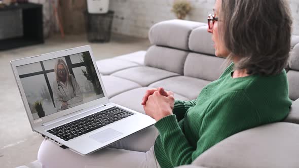 Mature Senior Woman is Using a Laptop at Home